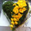 Gelbes Herz getrennt mit Blumen gesteckt