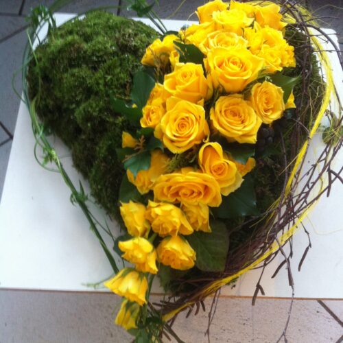 Gelbes Herz getrennt mit Blumen gesteckt