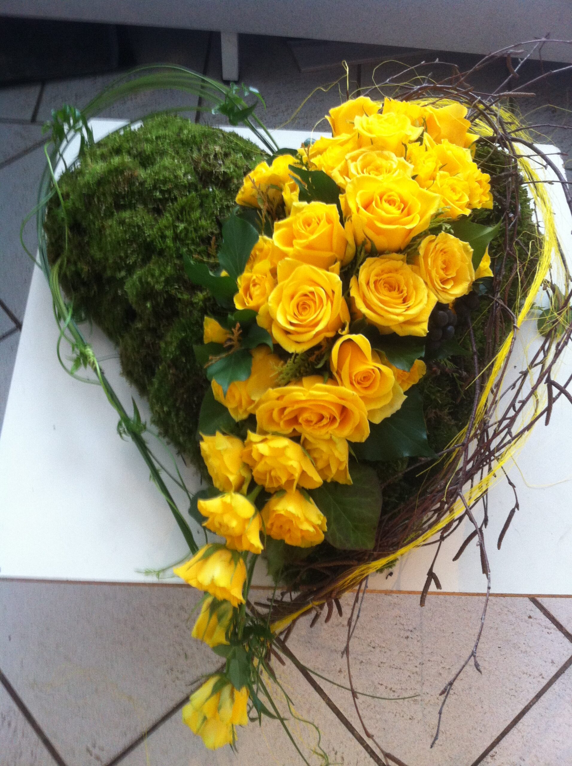 Gelbes Herz getrennt mit Blumen gesteckt